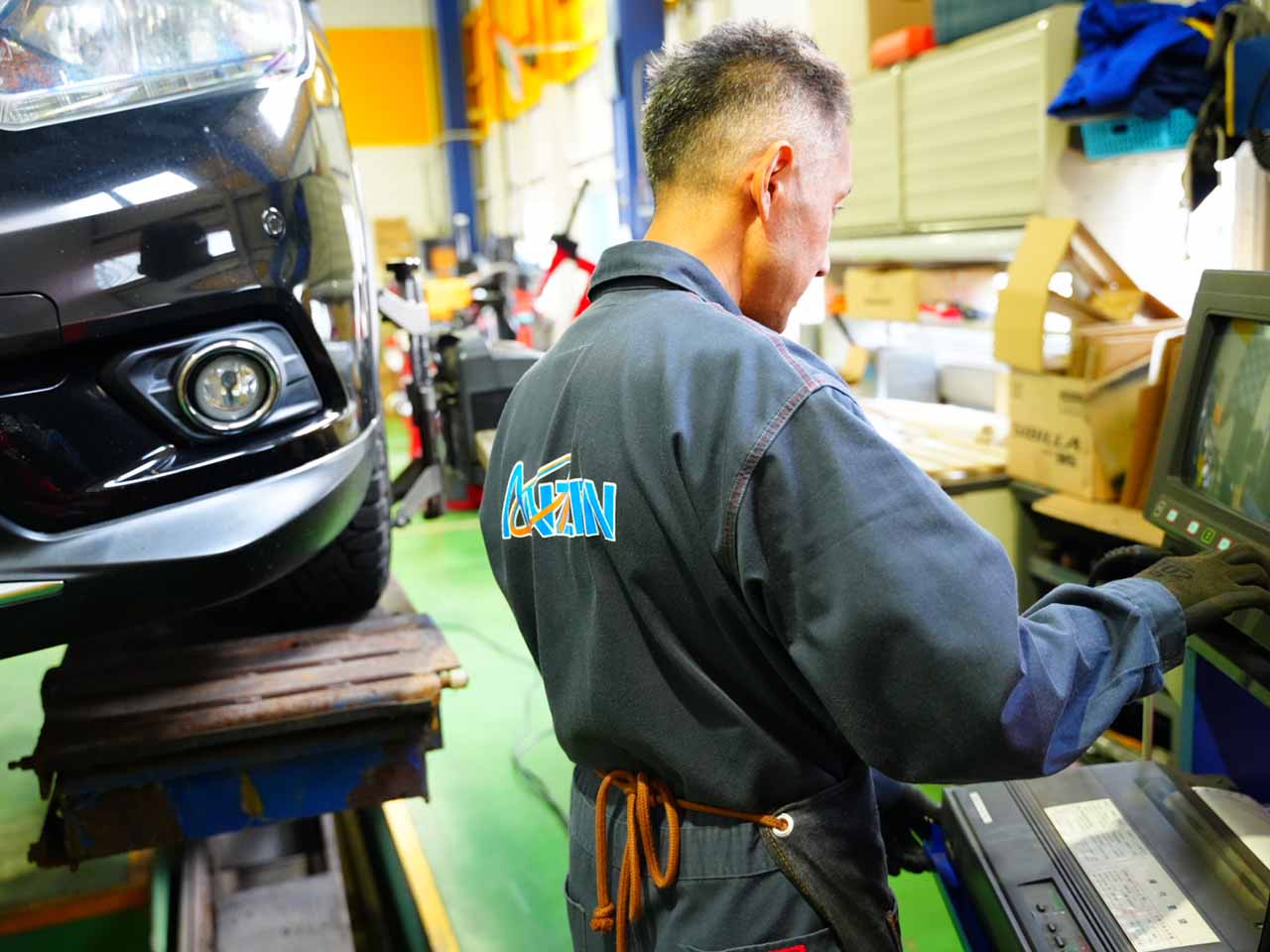 モニターを見ながらアライメント調整作業をしている整備士