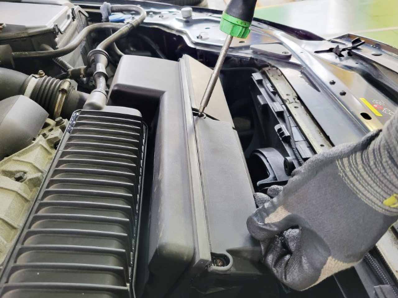 車検 エアーエレメント交換作業をしている整備士の手元