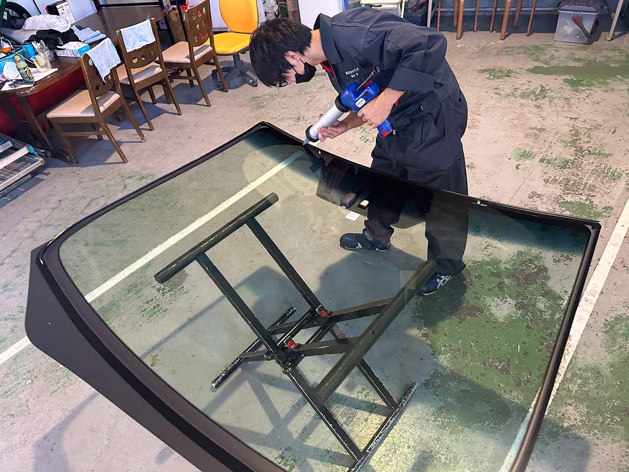 ベテランのスタッフによるフロントガラスの接着剤の充填作業