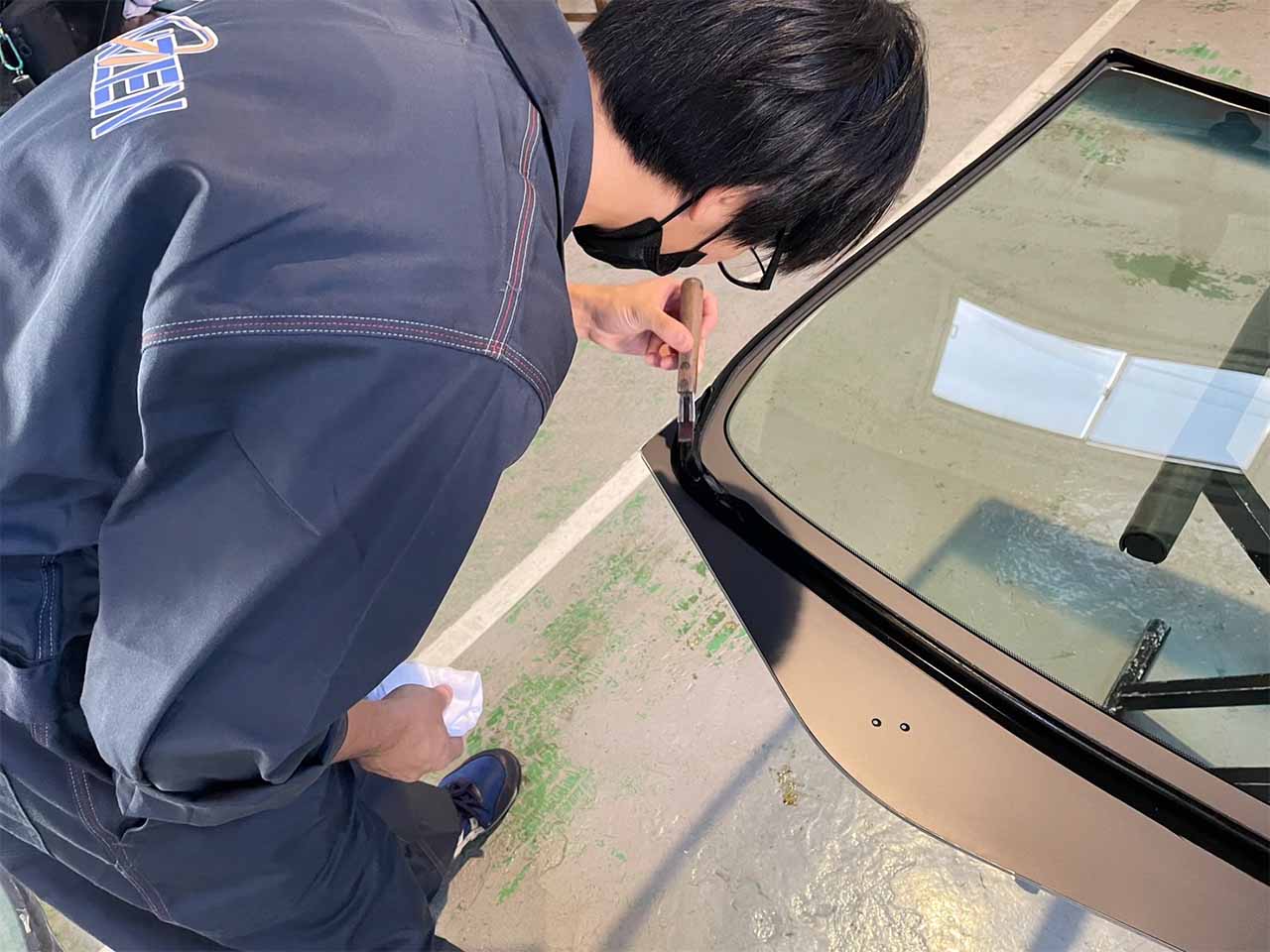 新品のフロントガラスの接着面にプライマーを塗布する