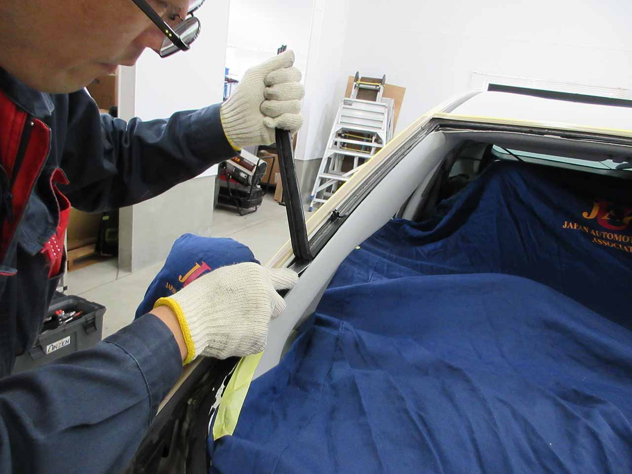フロントガラスについた古い接着剤の除去作業