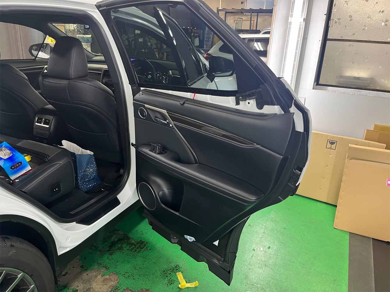 後部席右側のドアが開かれた白い車